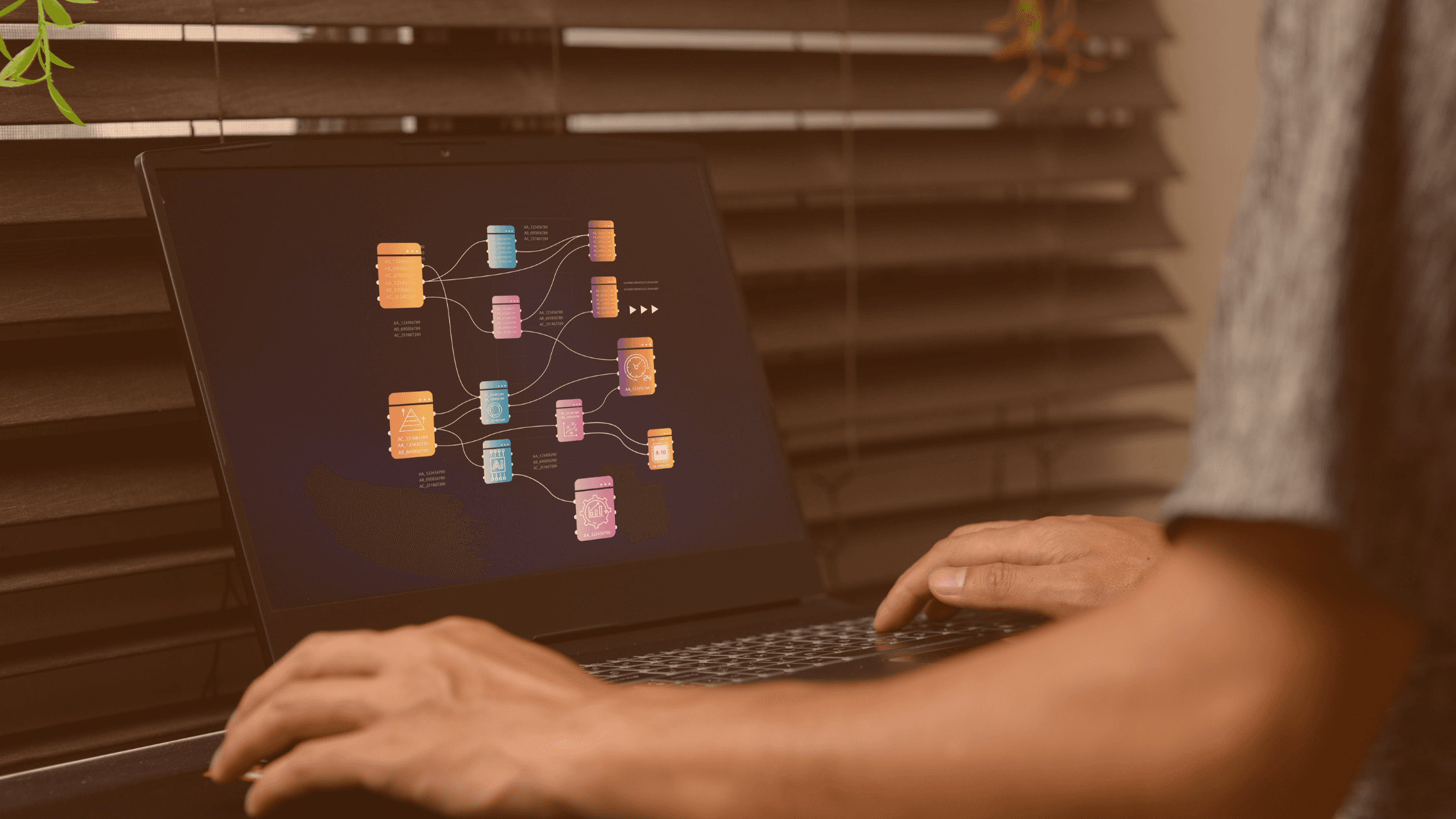 Hands typing on a laptop with AI data visualisation and workflow systems on screen.